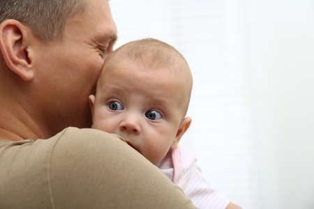 Father with his little baby on white background, closeup. Space for text