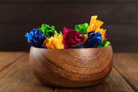 Candies in colorful wrappers on wooden table, closeup
