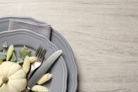 Festive table setting with autumn decor on wooden background, top view. Space for textの写真素材