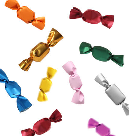 Tasty candies in colorful wrappers falling on white backgroundの写真素材