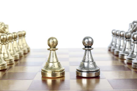 Chess pieces on wooden board against white background