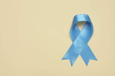 Light blue awareness ribbon on beige background, top view. Space for textの写真素材