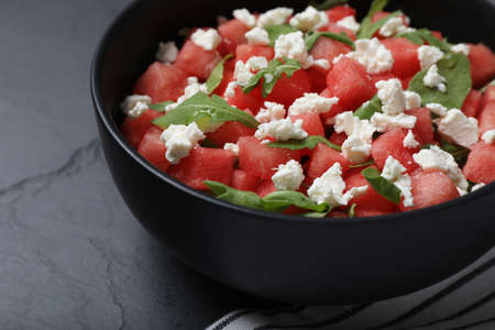 Delicious salad with watermelon, arugula and feta cheese on black table, closeupの写真素材