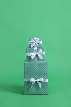 Stack of beautifully wrapped gift boxes on green backgroundの写真素材
