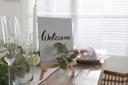 Festive table setting with floral decor and Welcome sign indoorsの写真素材
