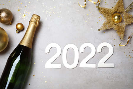 Happy New Year 2022! Flat lay composition with bottle of sparkling wine on light gray tableの写真素材