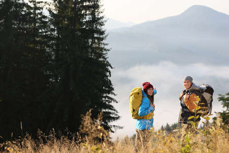 Tourists with backpacks in mountains on sunny day. Space for textの写真素材
