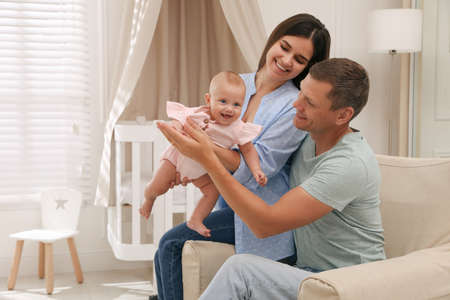 Happy family with their cute baby at home