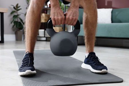Man training with kettlebell at home, closeupの写真素材
