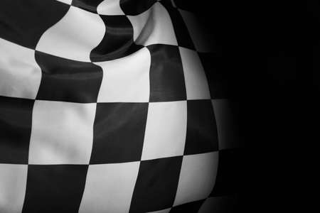 Checkered finish flag on black background, closeupの写真素材