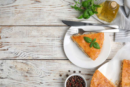 Delicious meat pie served on white wooden table, flat lay. Space for text