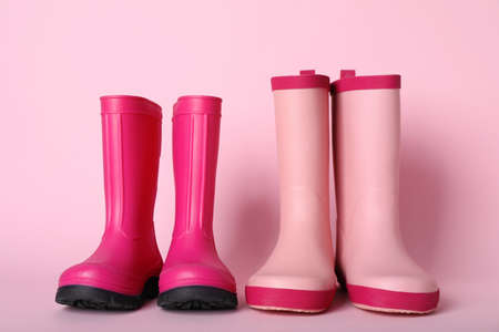 Two pairs of rubber boots on pink backgroundの写真素材