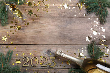Happy New Year 2023! Flat lay composition with bottle of sparkling wine on wooden table, space for...