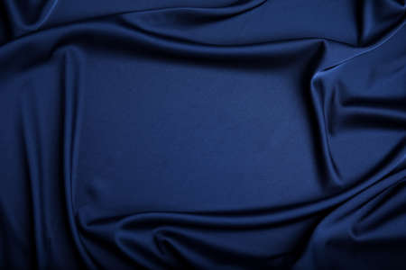 Crumpled dark blue silk fabric as background, top view. Space for textの写真素材