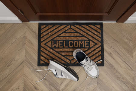 Stylish shoes near door mat in hall, top viewの写真素材