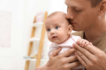 Happy father with his little baby at home. Space for text