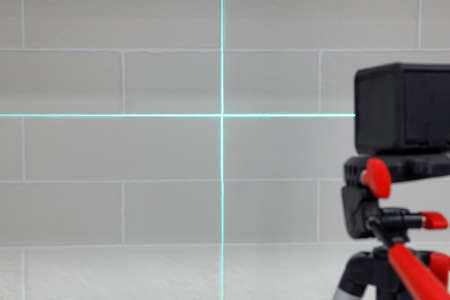 Cross lines of laser level on white brick wallの写真素材