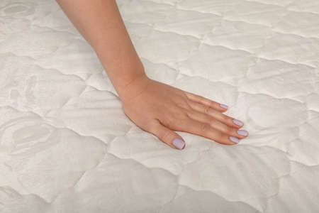 Woman touching soft comfortable mattress, closeup of handの写真素材