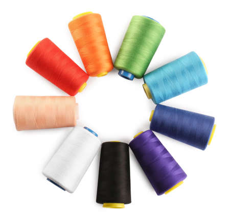 Frame of colorful sewing threads on white background, top view. Space for text