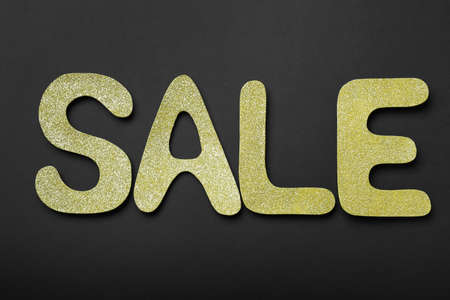Word Sale made of golden letters on dark background, flat lay. Black Fridayの写真素材