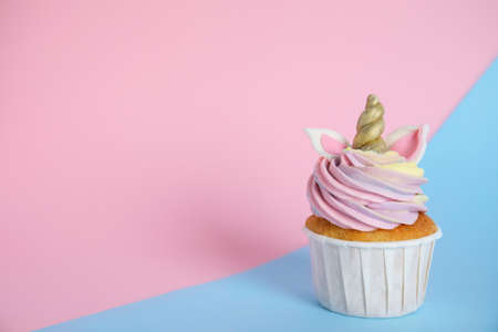 Cute sweet unicorn cupcake on color background. Space for text