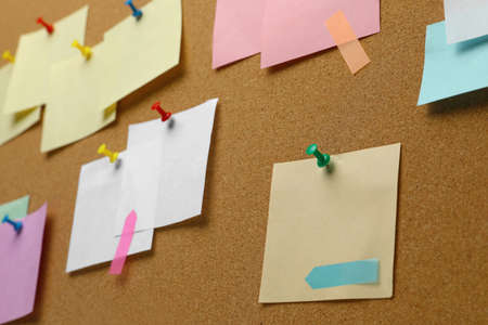 Colorful paper notes pinned to cork board, closeupの写真素材