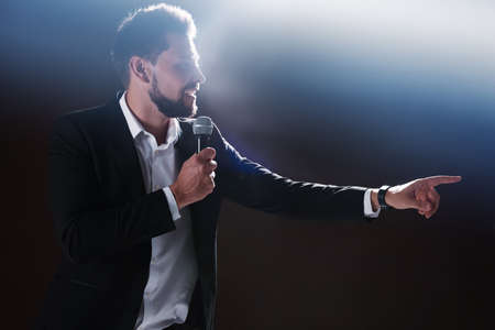 Motivational speaker with microphone performing on stage