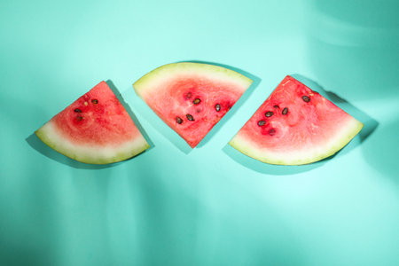 Slices of delicious ripe watermelon on turquoise background, flat lay