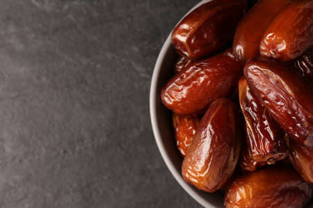 Tasty sweet dried dates in bowl on black table, top view. Space for textの写真素材