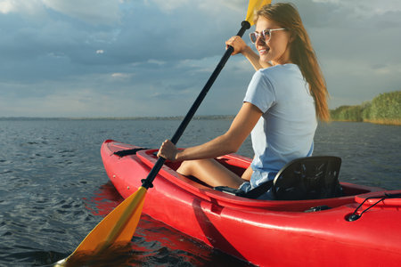 Happy woman kayaking on river. Summer activity