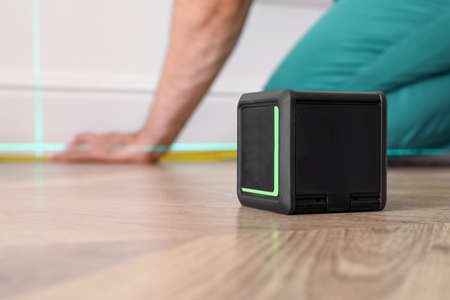 Cross line laser level on wooden floor indoors