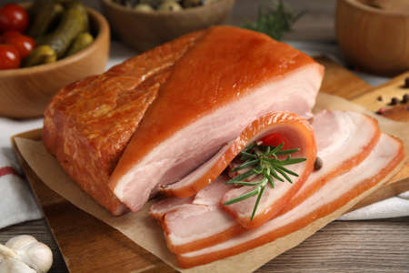 Delicious smoked bacon with rosemary on wooden table, closeupの写真素材