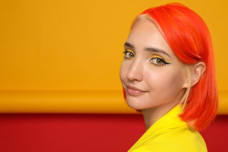 Beautiful young woman with bright dyed hair on color background, space for textの写真素材