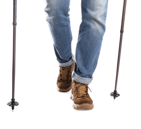 Man wearing stylish hiking boots with trekking poles on white background, closeupの写真素材