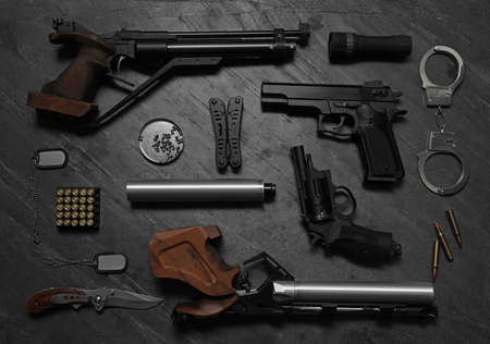 Flat lay composition with different guns on dark tableの写真素材