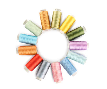 Frame of colorful sewing threads on white background, top view. Space for text