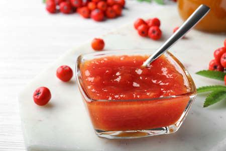Delicious rowan jam in glass bowl on white wooden table, closeupの写真素材