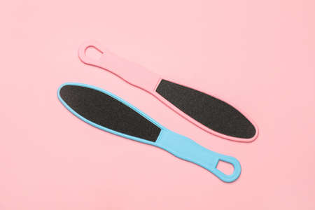 Colorful foot files on pink background, flat lay. Pedicure tools