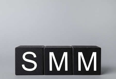 Black cubes with abbreviation SMM (Social media marketing) on gray backgroundの写真素材