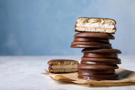 Stack of tasty choco pies on gray table. Space for text