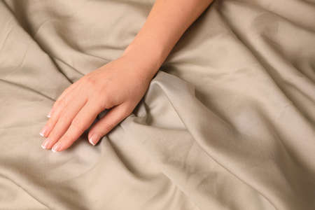 Woman touching smooth gray fabric, closeup view