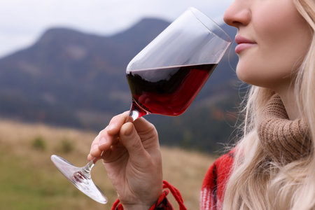 Young woman drinking wine in peaceful mountains, closeupの写真素材