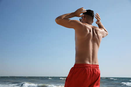 Man with attractive body on beach, back viewの写真素材