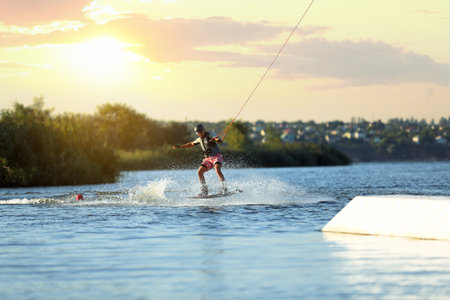 Teenage boy wakeboarding on river. Extreme water sportの写真素材