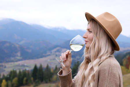 Young woman drinking wine in peaceful mountainsの写真素材