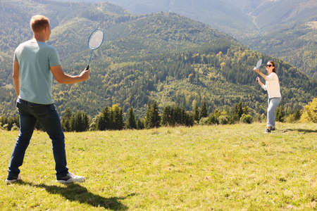 Couple playing badminton in mountains on sunny dayの写真素材