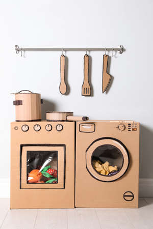 Cardboard kitchen and washing machine near white wall indoorsの写真素材
