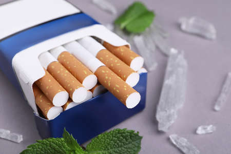 Pack of cigarettes, menthol crystals and mint leaves on gray background, closeupの写真素材