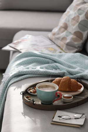 Tray with tasty breakfast on gray sofa in morning. Space for textの写真素材