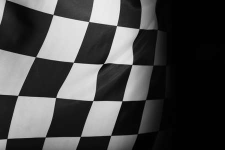 Checkered finish flag on black background, closeupの写真素材